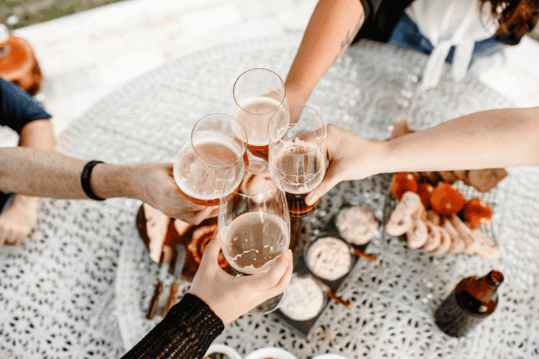 Friends enjoying a kombucha functional beverage while sharing drinks and appetizers at an outdoor gathering.